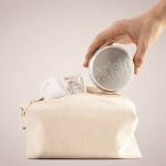 arista-shampoo-bar-holder-box-travel-friendly-leakproof-square a hand holding arista shampoo bar tin box
